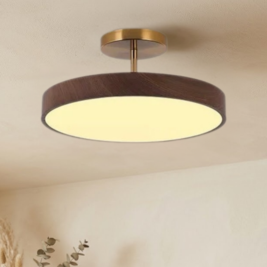 Dezelfde lamp met donkere houtlook rand en goudkleurige steun, brandend aan het plafond, gezien iets van opzij. 3