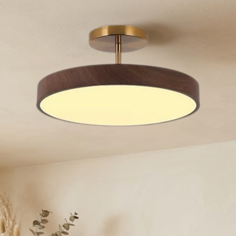 Dezelfde lamp met donkere houtlook rand en goudkleurige steun, brandend aan het plafond, gezien iets van opzij. 3