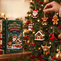 Een hand hangt een bouwsteenfiguurtje aan een verlichte kerstboom, met onder meer kerstman, rendier, pinguïn en peperkoekmannetje eraan. 3