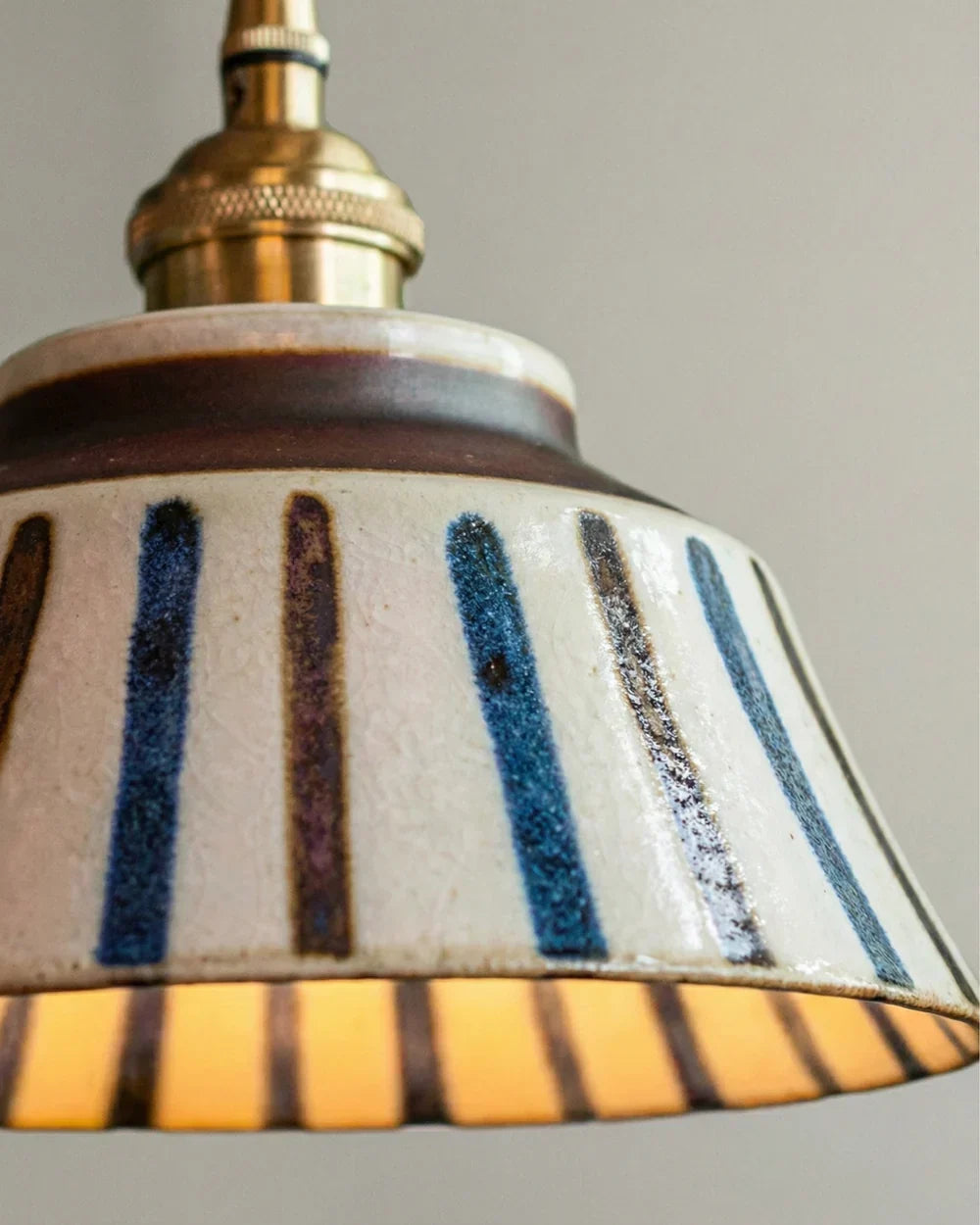 Close-up van de gestreepte keramische kap met handgeschilderde blauwe en bruine strepen, glazuur en messing lampfitting. 7