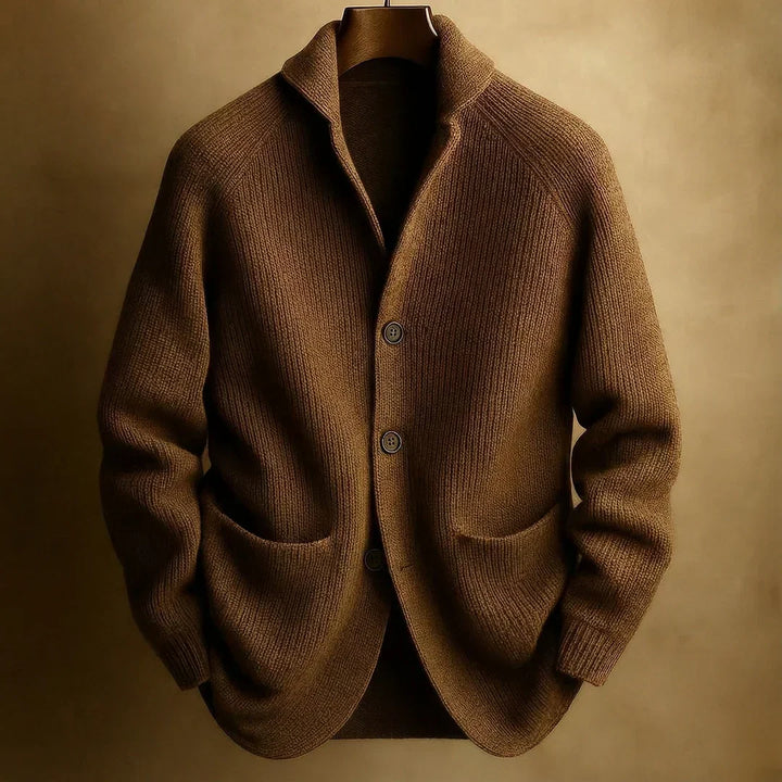 Bruin gebreid vest met sjaalkraag en drie knopen, hangend aan een houten hanger tegen een warme beige achtergrond 7