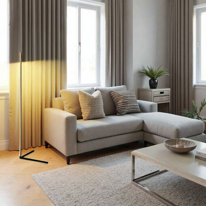 Lamp met warm licht die een gordijn beschijnt, in een lichte woonkamer met crèmekleurige hoekbank en salontafel 10