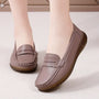 Mauvebruine leren loafers met gescalloped penny-strook zonder gevlochten band, gedragen op een crèmekleurig tapijt. 13