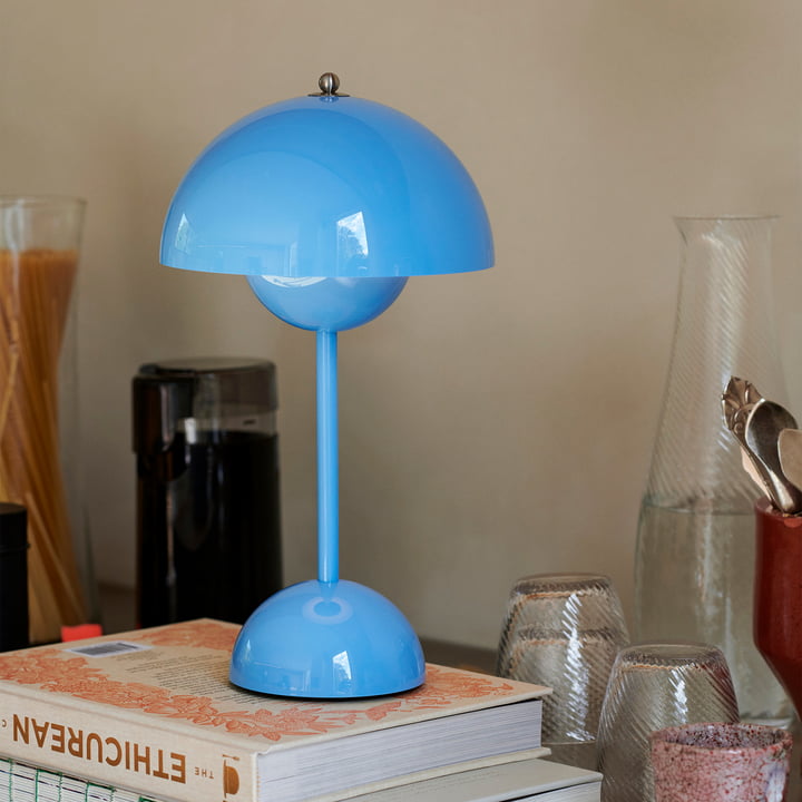 Lichtblauwe lamp op een stapel boeken in een keuken met glaswerk en een koffiemolen 39