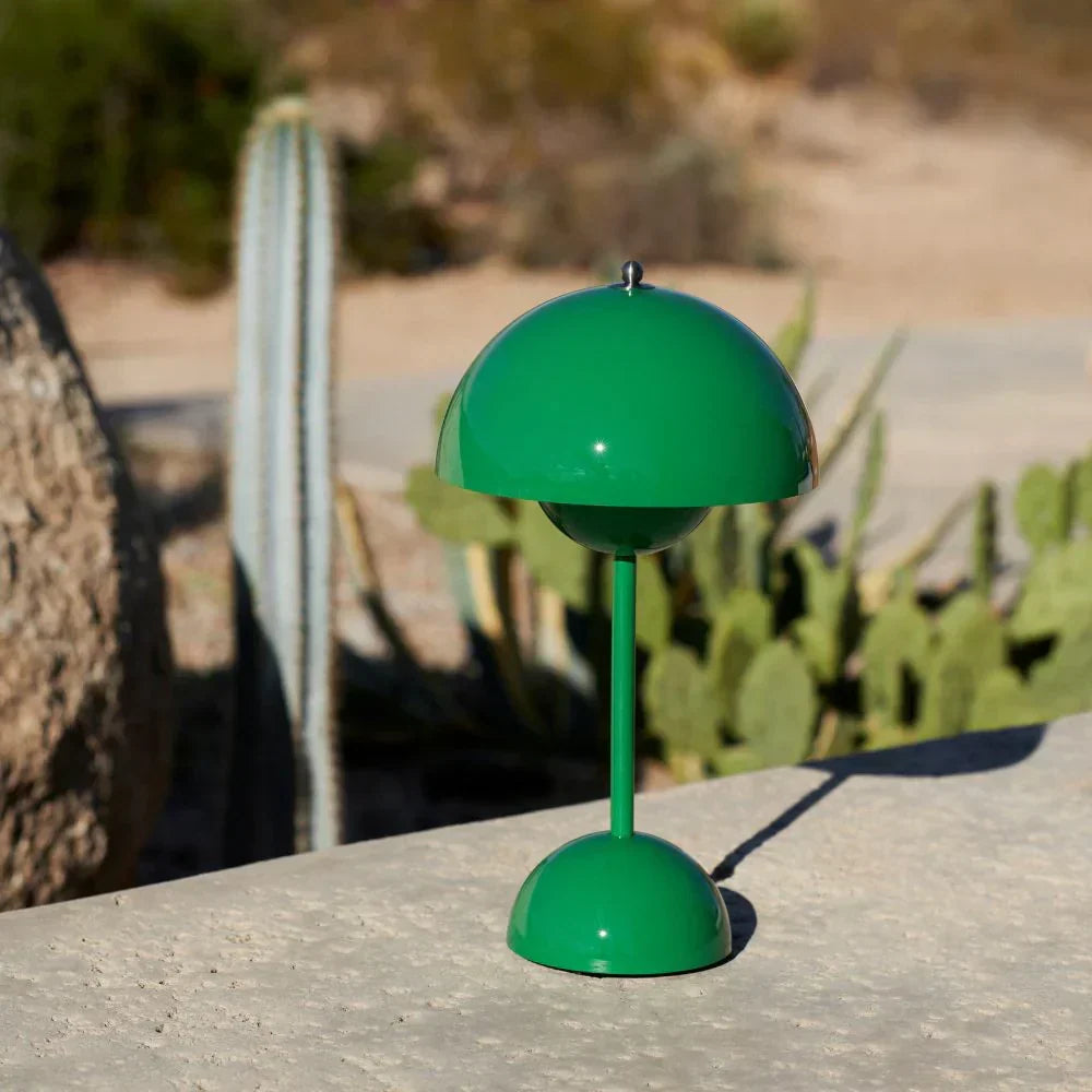 Groene lamp op een betonnen muurtje buiten, met cactussen op de achtergrond 28