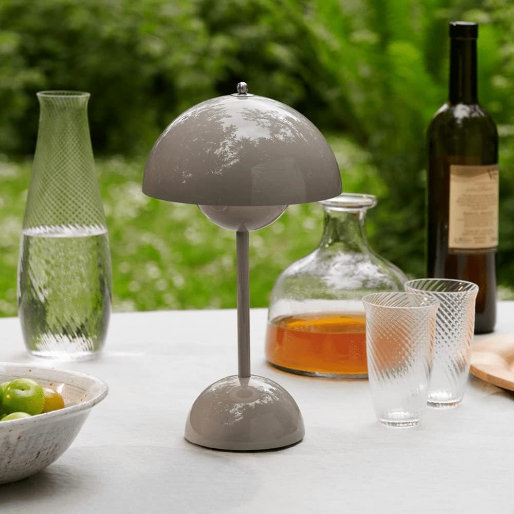 Taupekleurige lamp op een buitentafel met karaf, glazen met streeppatroon, fruitschaal en fles 32