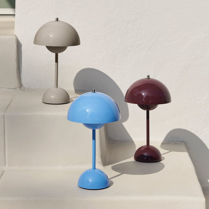 Drie lampen in beige, lichtblauw en bordeauxrood staan op witte trappen met scherpe schaduwen 38