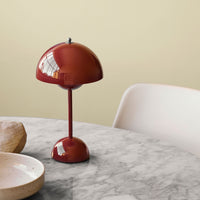 Rode glanzende lamp met koepelkap en ronde voet op een marmeren tafel met keramische schaaltjes 44