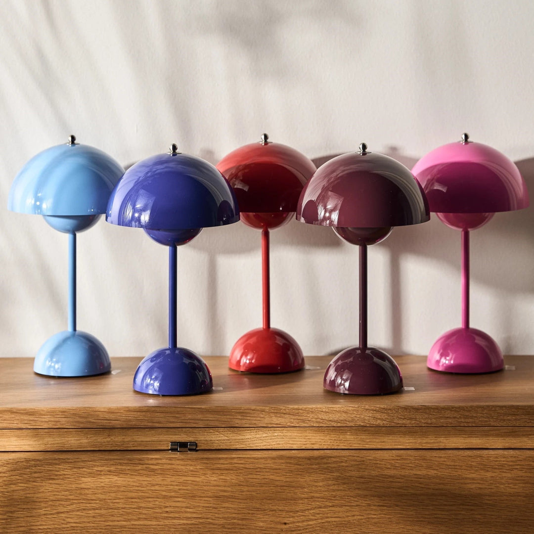 Vijf glanzende lampen in blauw, paars, rood, bordeaux en roze op een houten kast 14