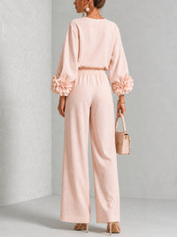 Achteraanzicht van de roze set met bloemen aan de mouwen en elastische taille 9