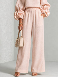 Detail van de roze wijde broek met elastische taille, zakken en bloemmouwen 11