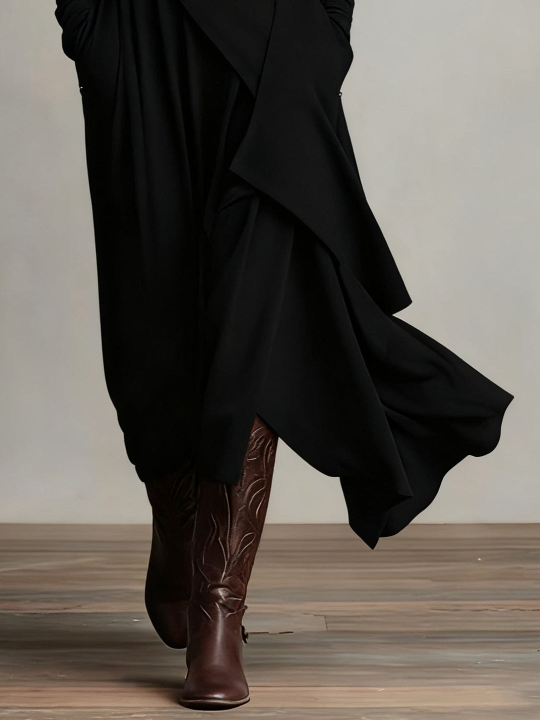 Detail van de zwarte asymmetrische rok met golvende lagen boven gegraveerde laarzen 8