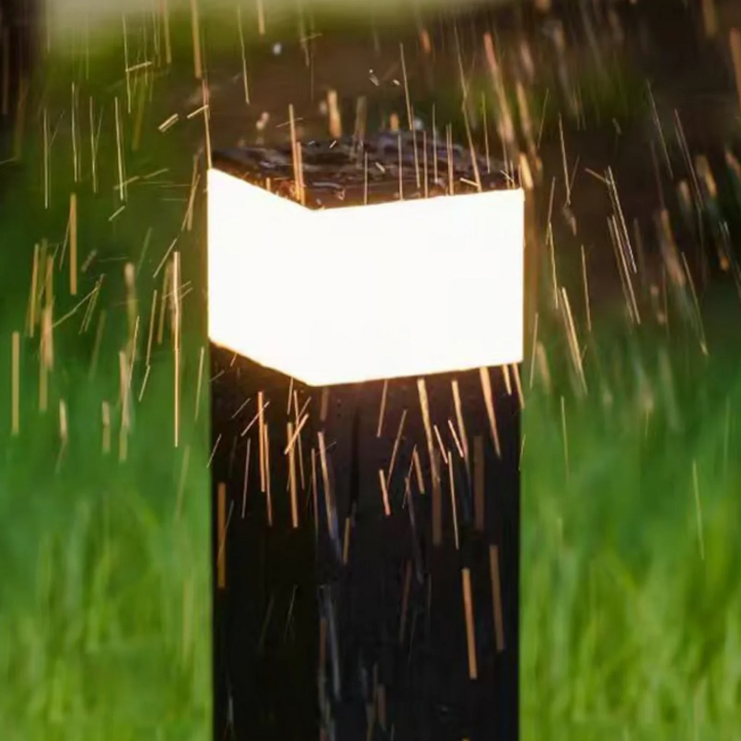 Close-up van het oplichtende bovenstuk van een zwarte lichtpaal in vallende regen, ter illustratie van de waterbestendigheid. 9