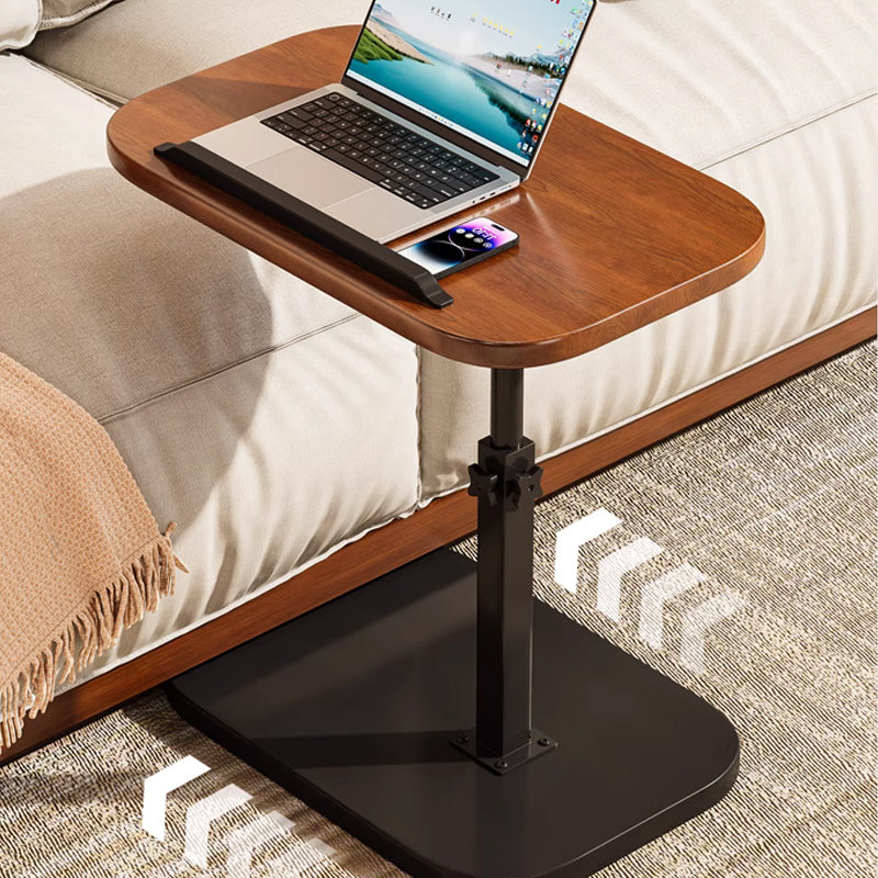 Laptoptafel in notenhout naast een bank met laptop en telefoon, met pijlen op de vloer die het verrijden over het kleed tonen. 10