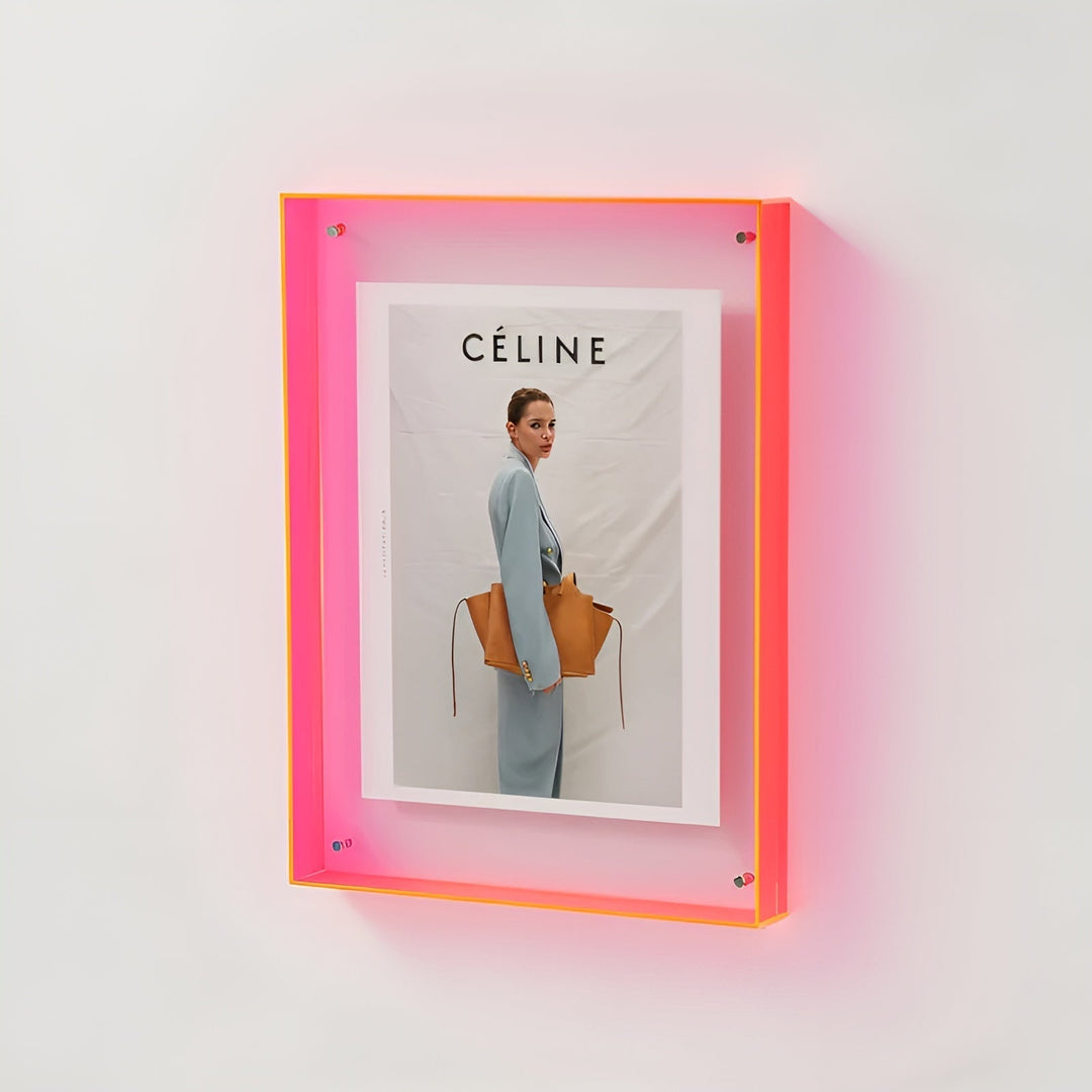 Neonroze acryl lijst aan de muur met een foto van een vrouw in lichtblauw pak met een bruine tas. 18