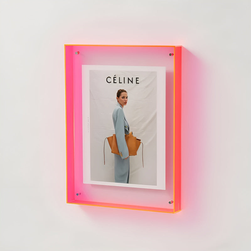 Neonroze acryl lijst aan de muur met een foto van een vrouw in lichtblauw pak met een bruine tas. 18
