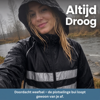 Lachende vrouw met capuchon in een zwarte jas met reflecterende strepen, nat van de regen, aan een rivier. 8