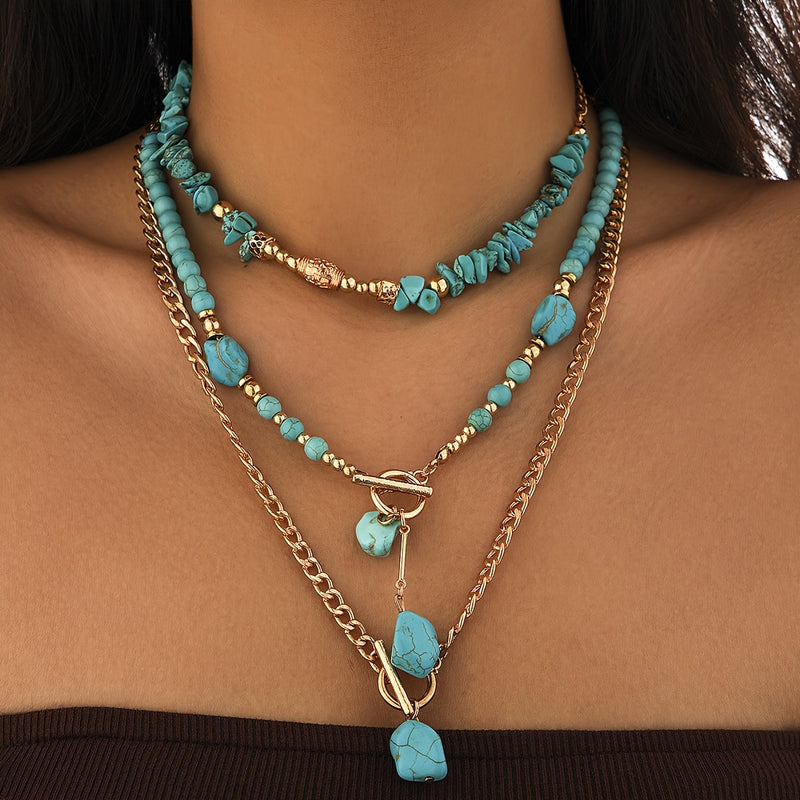 Gelaagde set van drie kettingen met turquoise stenen, gedragen om de hals van een vrouw 6