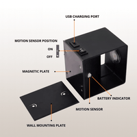 Zwarte lamp met losse magnetische montageplaat ernaast, met aanduidingen van usb-oplaadpoort, schakelaar, bewegingssensor en batterij-indicator. 5