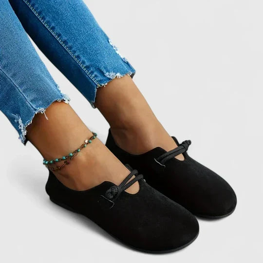 Zwarte loafers met ronde neus en touwsluiting, zijaanzicht aan de voeten met gerafelde spijkerbroek 2