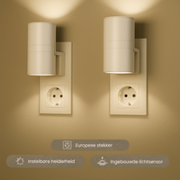 Twee witte cilindervormige stekkerlampen in stopcontacten geven warm licht omhoog en omlaag op een beige muur 2