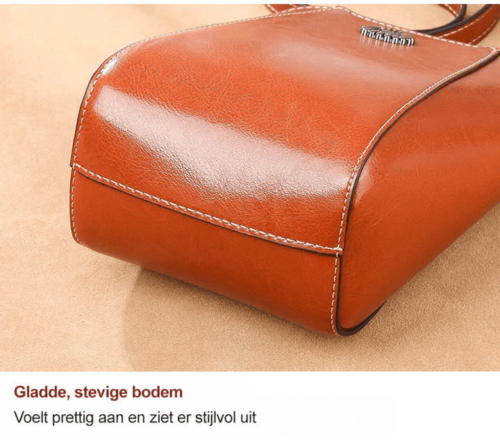 Close-up van de gladde, afgeronde onderkant van de roodbruine leren tas met lichte stiksels 11