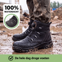 Zwarte werkschoenen met waterdruppels in de modder op een bouwplaats, gedragen onder een vuile werkbroek 5