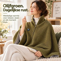Vrouw met een mok en boek draagt de olijfgroene cape over haar schouders op de bank 8