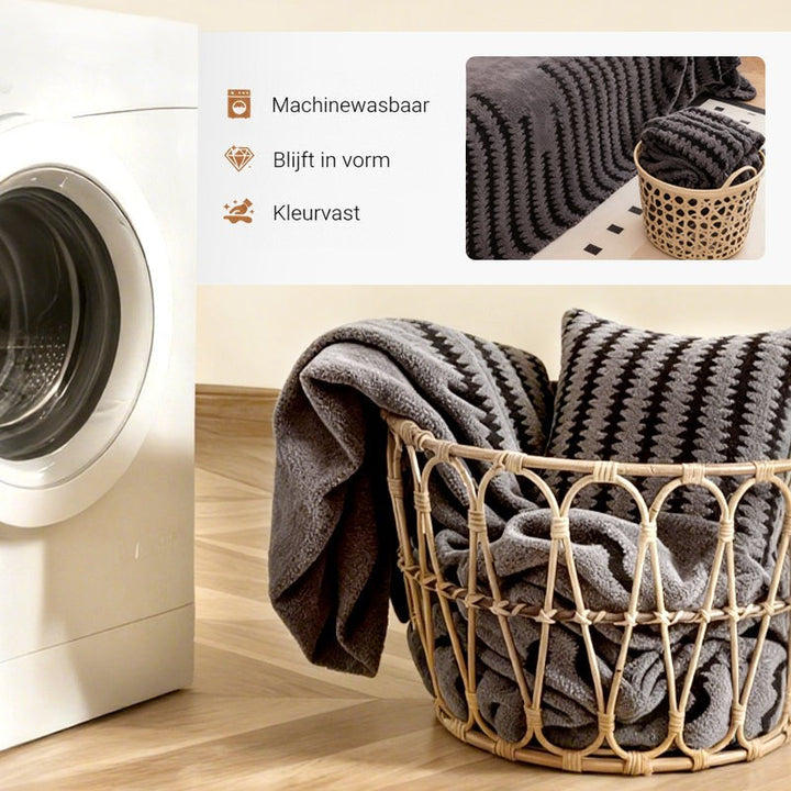 Opgevouwen grijze hoes en kussenhoes in een rieten mand naast een wasmachine 5