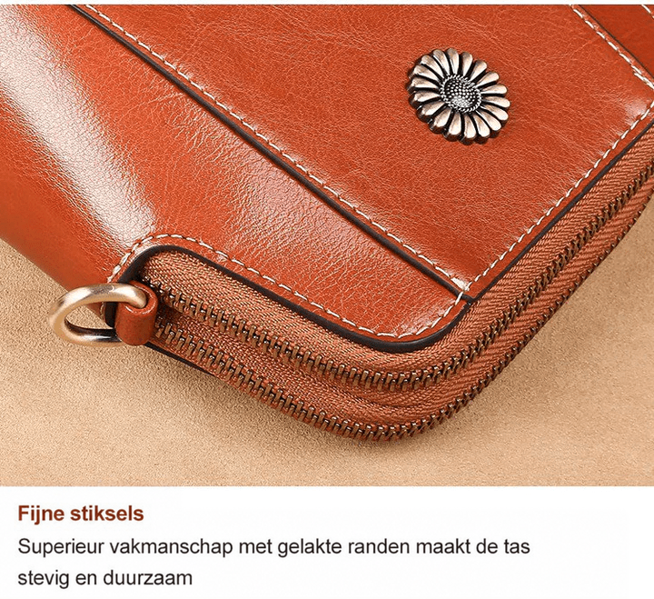 Close-up van de hoek met fijne stiksels, gelakte rand, rits, D-ring en bloemvormig sierstuk 16