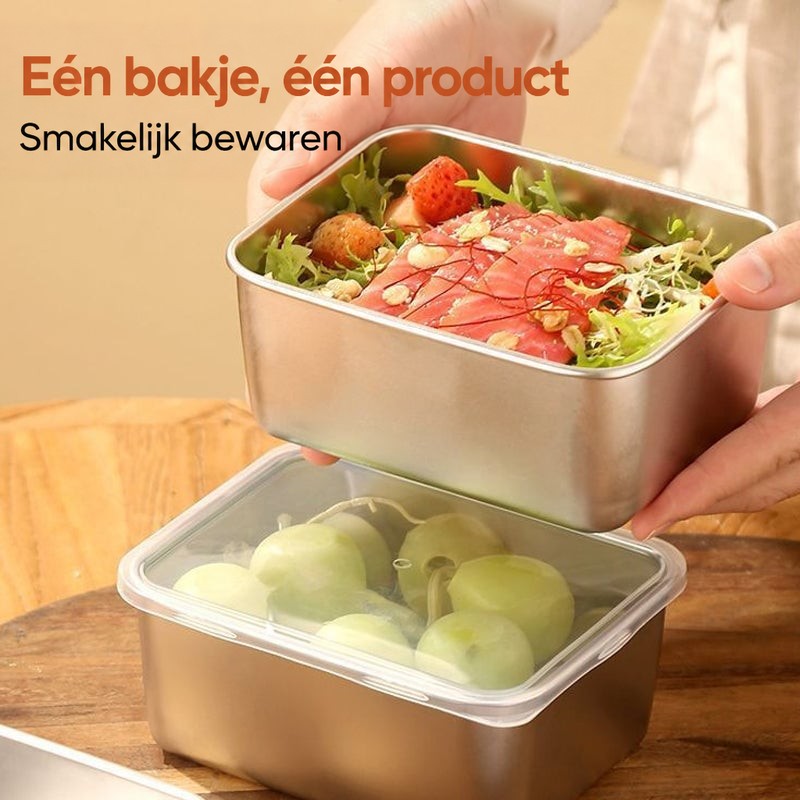 Hand houdt een bakje met salade en zalm boven een gesloten bakje met druiven, op een houten bord. 5