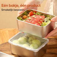 Hand houdt een bakje met salade en zalm boven een gesloten bakje met druiven, op een houten bord. 5