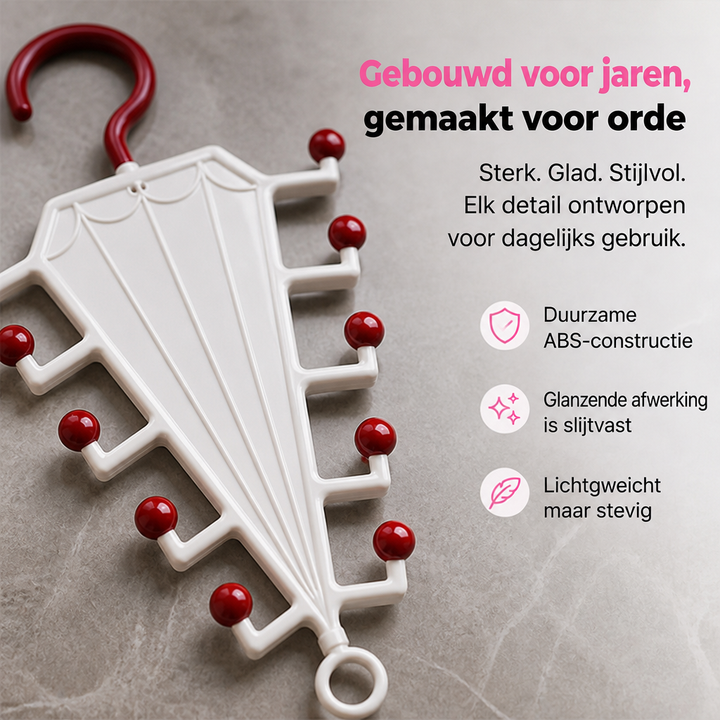 Wit paraplurek met rode bolletjes en rode haak, close-up liggend op een grijze steen-achtige ondergrond 3