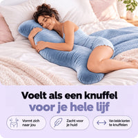 Vrouw slaapt op haar zij in bed en omhelst het blauwe S-vormige kussen 2