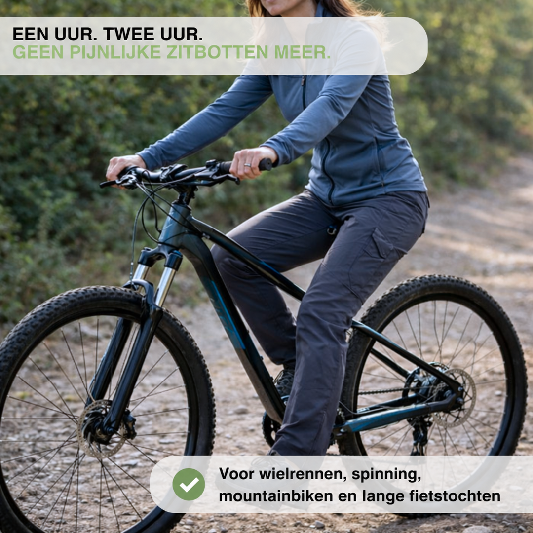 Vrouw in blauwe sportjas en grijze broek zit op een mountainbike op een zandpad 4