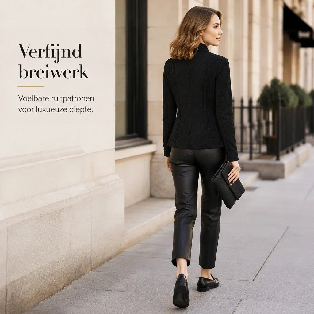 Vrouw van achteren in een zwarte blazer met diamant- en kabelstructuur, met leren broek, loafers en clutch op straat. 20