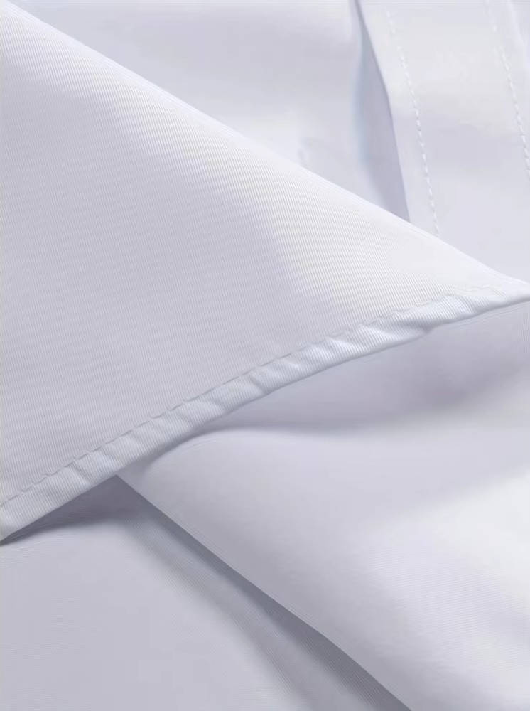 Detail van de witte stof met fijne structuur en dubbele stiksels langs de rand van de kraag 12