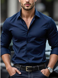 Model draagt het overhemd in marineblauw met opgerolde mouwen, gecombineerd met een zwarte riem en horloge 2