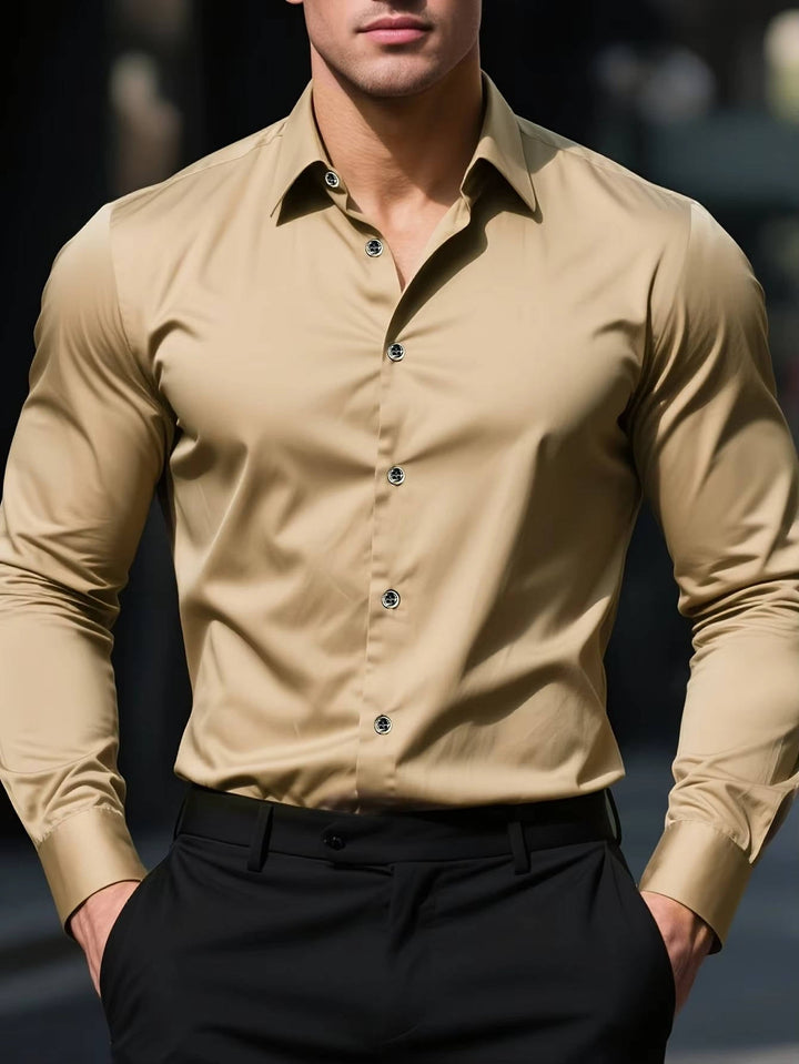 Model draagt het overhemd in zandbeige met zwarte pantalon, beide handen in de zakken 7