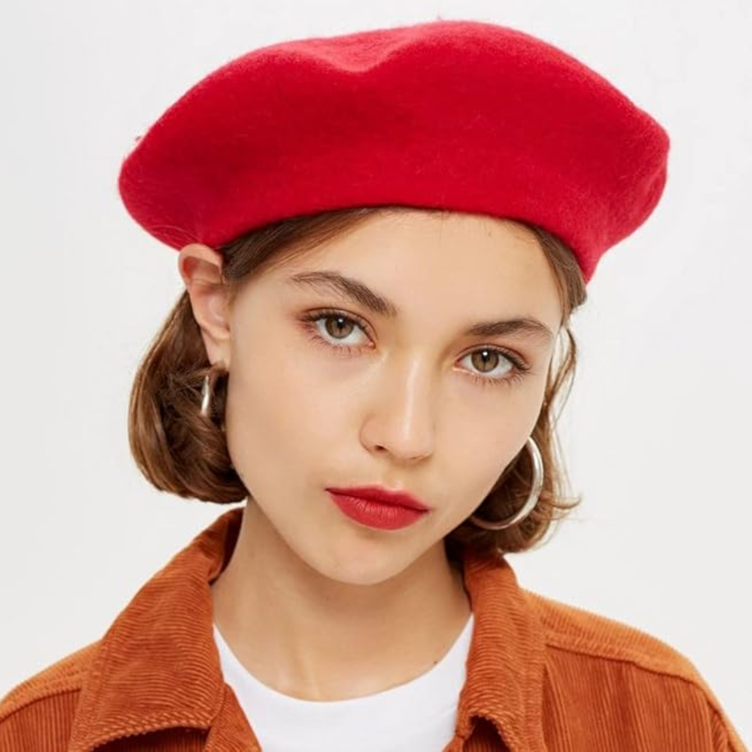 Vrouw draagt de rode baret schuin op het hoofd, met oranje corduroy jasje en witte top 21