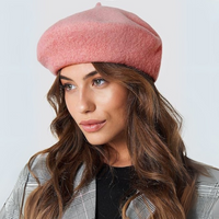 Vrouw met lang bruin haar draagt een roze wollen baret met grijze blazer 14