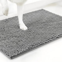 Witte hondenpoot staat op een grijze chenille mat, schuin van boven gefotografeerd tegen een witte achtergrond. 12