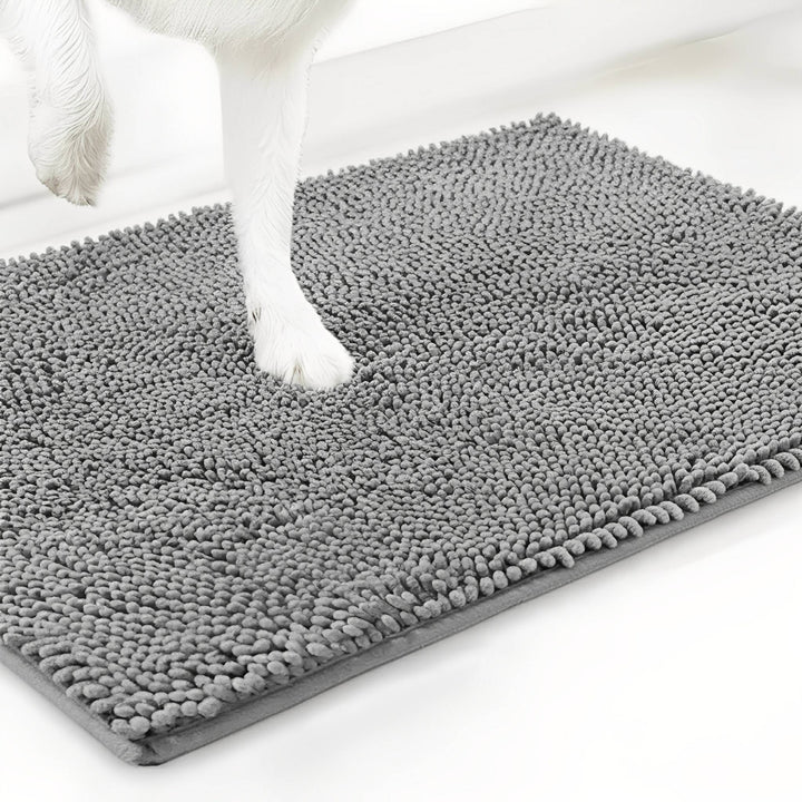 Witte hondenpoot staat op een grijze chenille mat, schuin van boven gefotografeerd tegen een witte achtergrond. 12