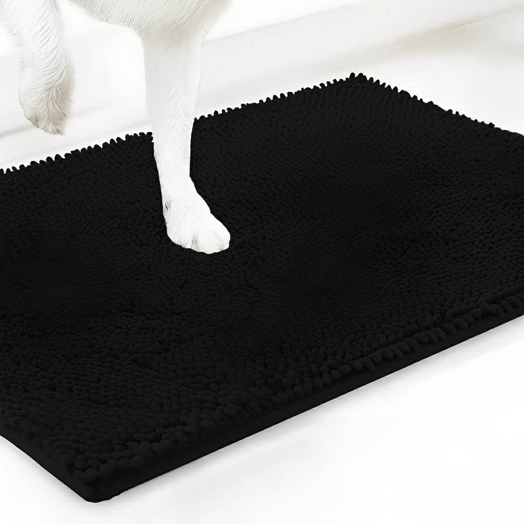 Zwarte variant van de chenille mat met een witte hondenpoot erop, tegen een witte achtergrond. 19