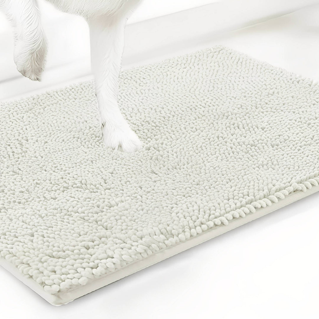 Gebroken witte variant van de chenille mat met een witte hondenpoot erop, tegen een witte achtergrond. 20