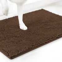 Bruine variant van de chenille mat met een witte hondenpoot erop, tegen een witte achtergrond. 18