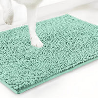 Mintgroene variant van de chenille mat met een witte hondenpoot erop, tegen een witte achtergrond. 15