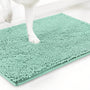 Mintgroene variant van de chenille mat met een witte hondenpoot erop, tegen een witte achtergrond. 15