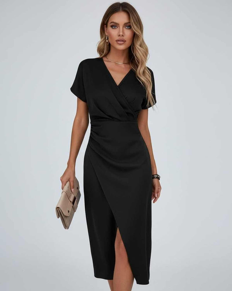 Model in zwarte midi-jurk met V-hals en split, met beige clutch in de hand 5