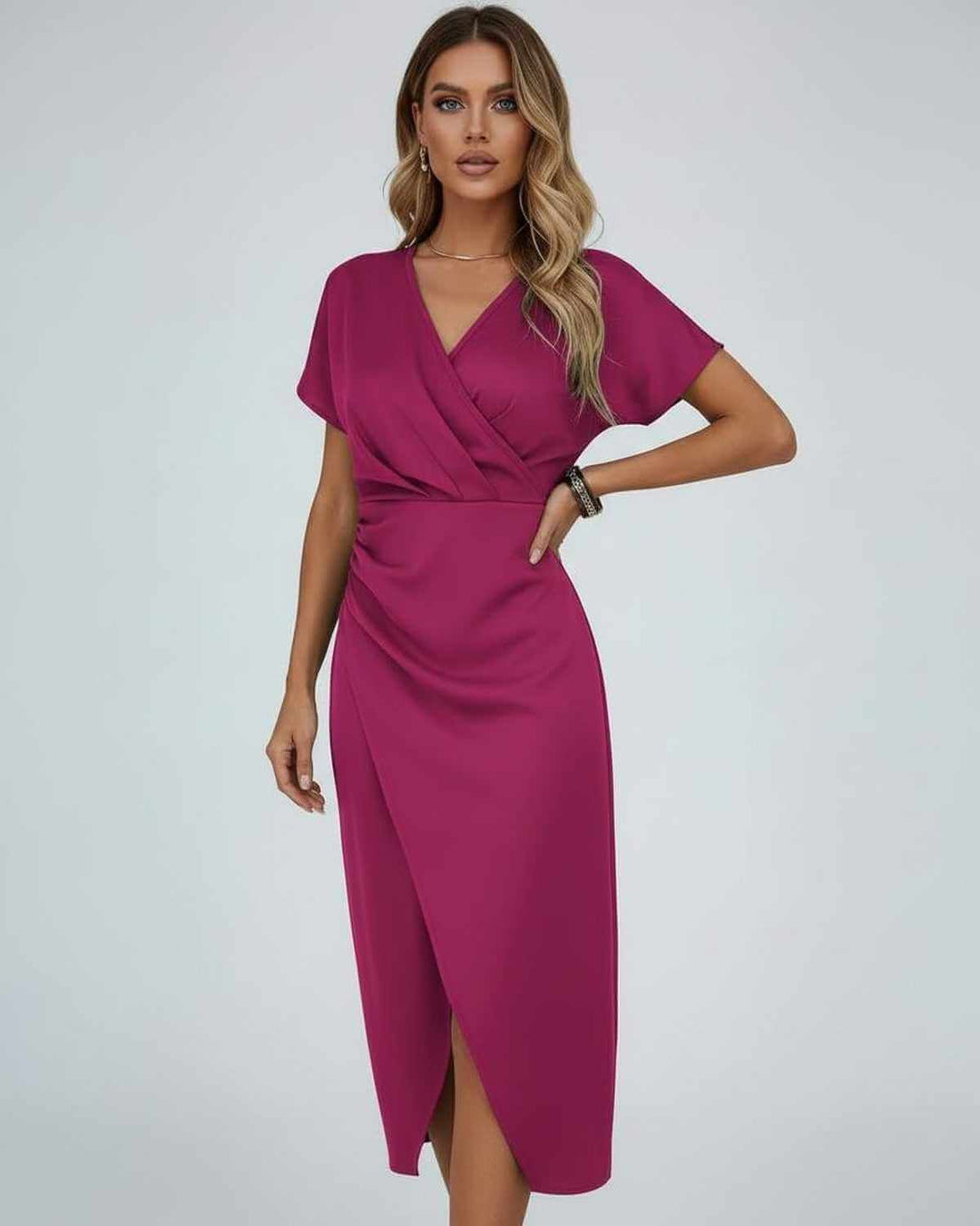 Model in fuchsia roze midi-jurk met korte mouwen, hand op de heup, split zichtbaar 1
